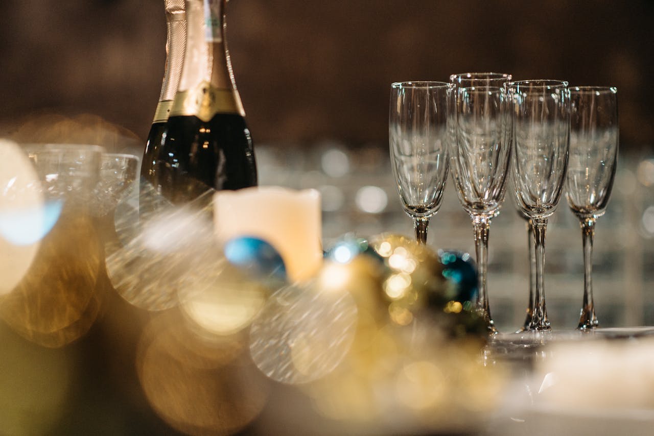 Champagne bottle and glasses with festive bokeh lighting for a celebratory atmosphere.